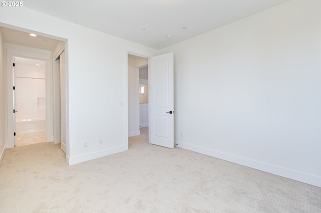 unfurnished bedroom featuring connected bathroom and light colored carpet