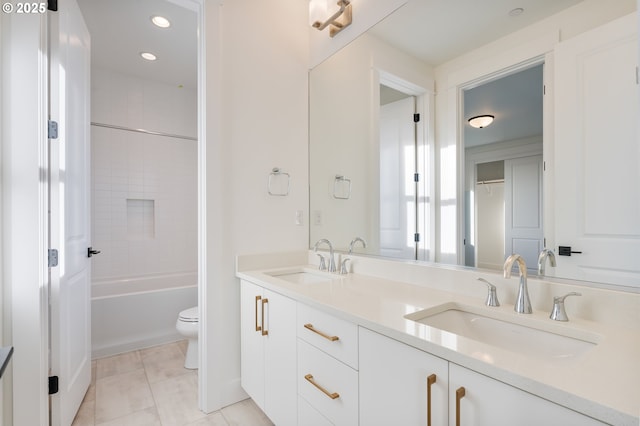 full bathroom with tile patterned flooring, vanity, tiled shower / bath combo, and toilet