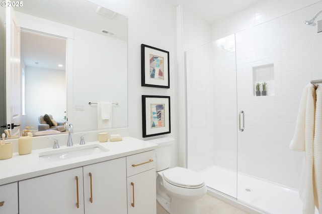 bathroom with vanity, a shower with door, and toilet