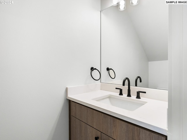 bathroom with vaulted ceiling and vanity