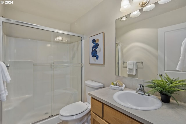 bathroom featuring toilet, vanity, and walk in shower