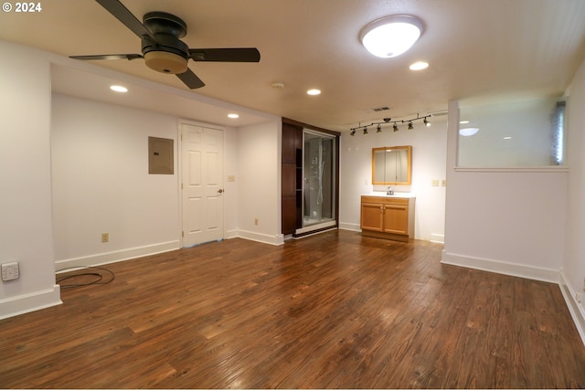 unfurnished living room featuring ceiling fan, dark hardwood / wood-style flooring, sink, and electric panel