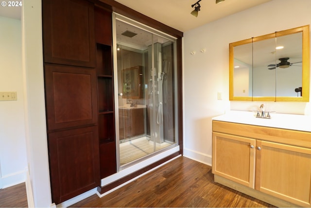 bathroom featuring wood-type flooring, vanity, a shower with door, and ceiling fan