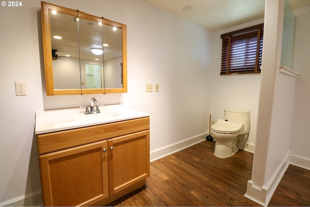 bathroom featuring hardwood / wood-style floors, vanity, toilet, and ceiling fan