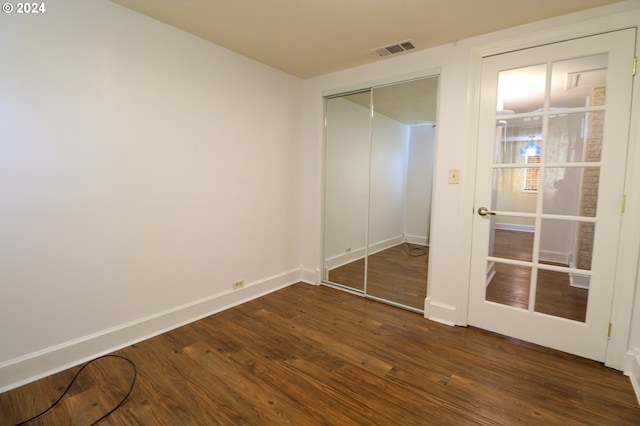 unfurnished bedroom with dark hardwood / wood-style flooring and a closet