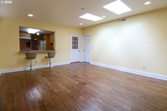 unfurnished living room featuring dark hardwood / wood-style flooring and sink