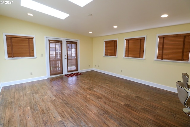 unfurnished room featuring french doors, hardwood / wood-style floors, and lofted ceiling