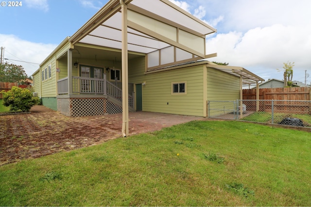 rear view of property featuring a patio area and a lawn