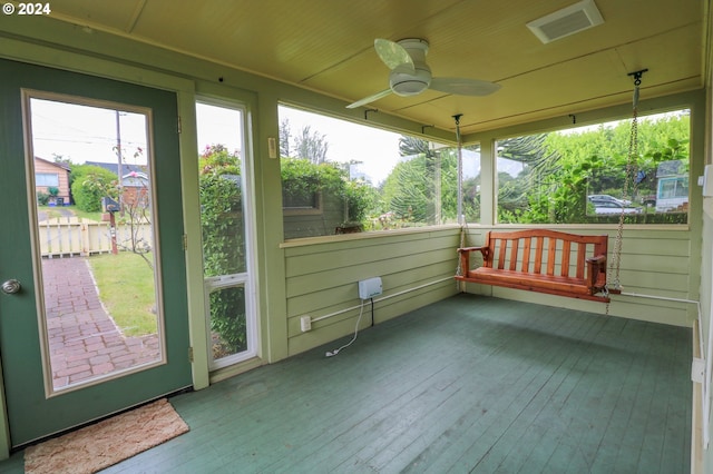 unfurnished sunroom with ceiling fan