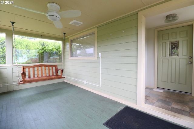 unfurnished sunroom with ceiling fan