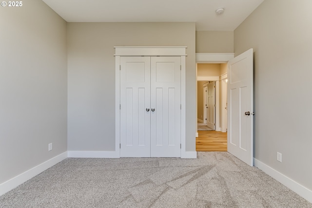 unfurnished bedroom featuring a closet and light carpet