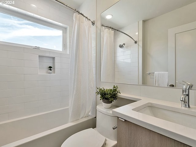 full bathroom with vanity, shower / bath combo with shower curtain, and toilet