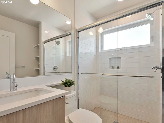 bathroom with vanity, tile patterned floors, toilet, and walk in shower