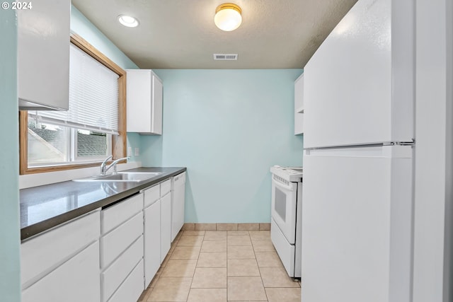 kitchen featuring white cabinetry, sink, a textured ceiling, white appliances, and light tile patterned flooring