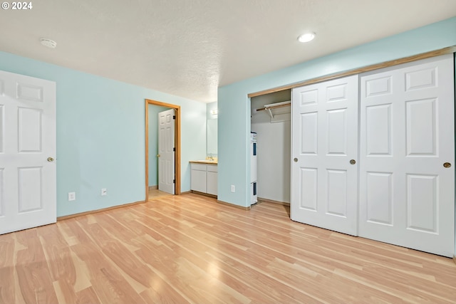 unfurnished bedroom featuring light hardwood / wood-style flooring and ensuite bath