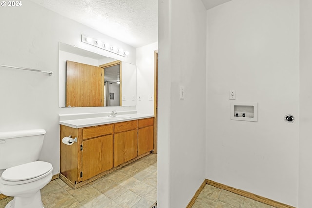 bathroom with vanity, toilet, and a textured ceiling