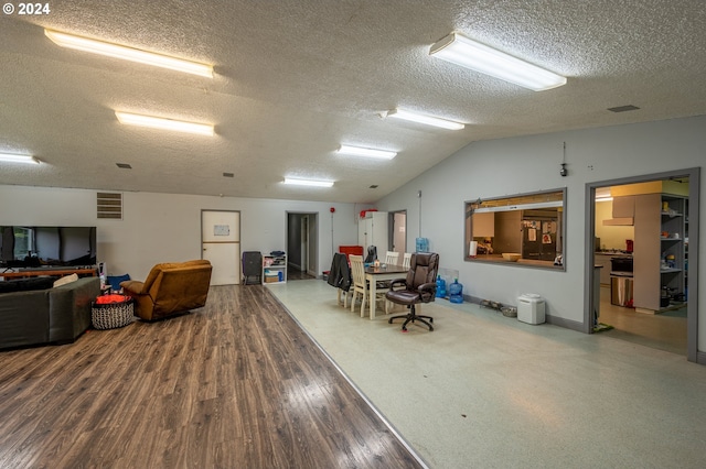 interior space featuring hardwood / wood-style floors, a textured ceiling, and vaulted ceiling