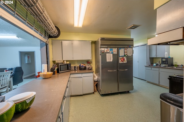 kitchen featuring white cabinets, appliances with stainless steel finishes, a textured ceiling, and sink