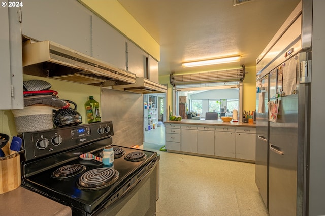 kitchen with black range with electric stovetop, built in refrigerator, and ventilation hood