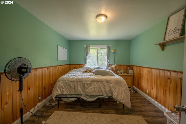 bedroom featuring dark hardwood / wood-style floors and wood walls