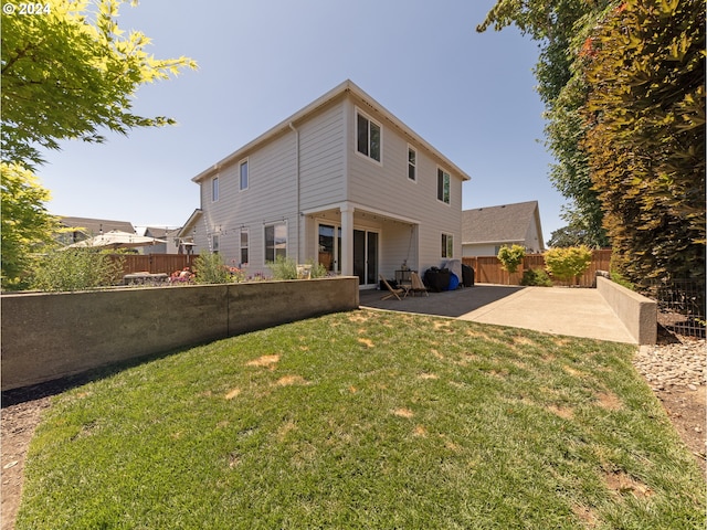 rear view of house featuring a yard and a patio