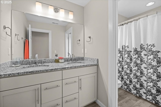 2410 S Heather St, Cornelius, OR 97113 - bathroom with double vanity, toilet, wood finished floors, a shower with shower curtain, and baseboards