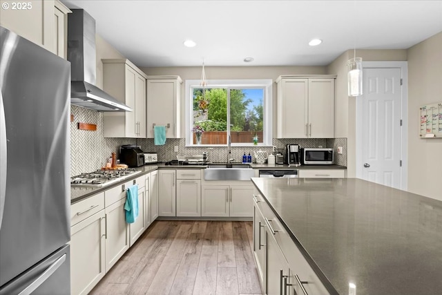 2410 S Heather St, Cornelius, OR 97113 - kitchen featuring stainless steel appliances, wall chimney exhaust hood, a sink, dark countertops, and light wood-type flooring