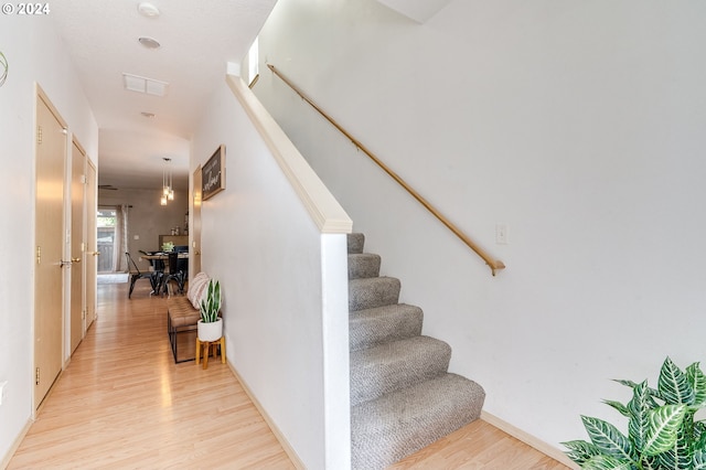 stairs featuring hardwood / wood-style floors