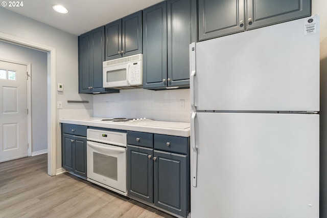 kitchen with white appliances, baseboards, light countertops, light wood-style flooring, and backsplash