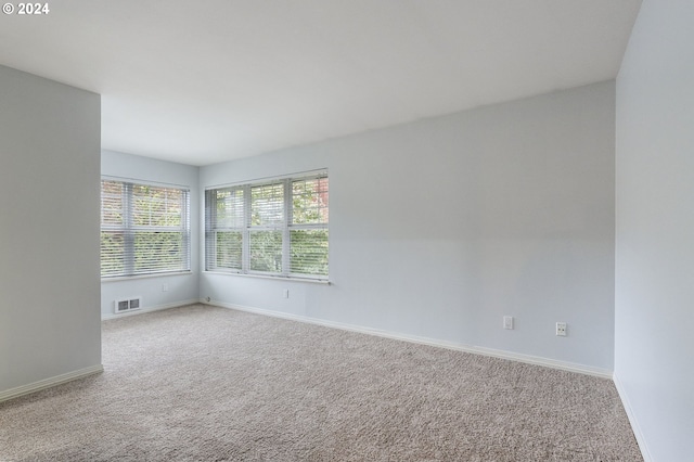 unfurnished room featuring baseboards, carpet, and visible vents