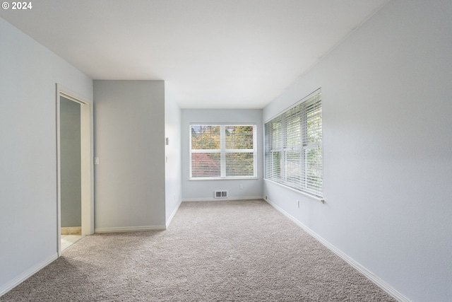 unfurnished room featuring carpet flooring, baseboards, and visible vents
