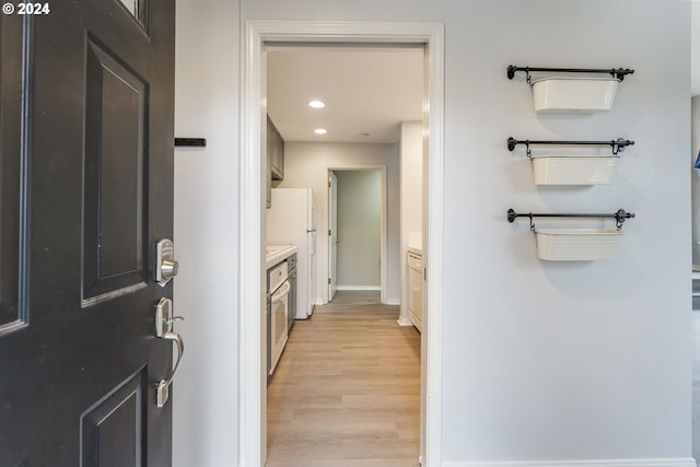 hallway featuring recessed lighting, baseboards, and light wood-style flooring