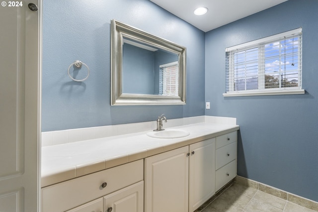 bathroom with baseboards, tile patterned flooring, and vanity