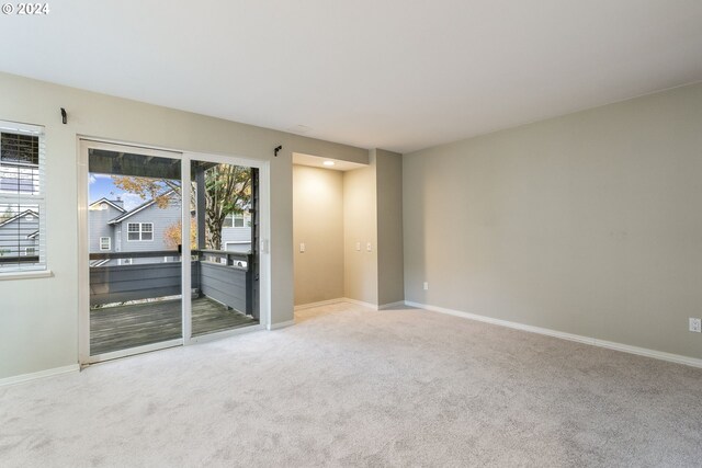 unfurnished room featuring carpet floors and baseboards