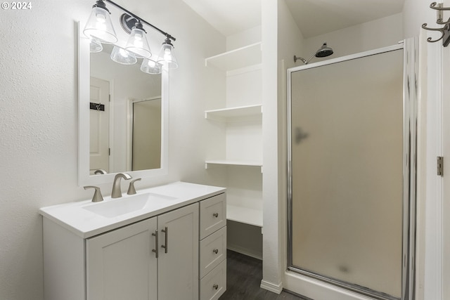 bathroom with vanity, a shower stall, and wood finished floors