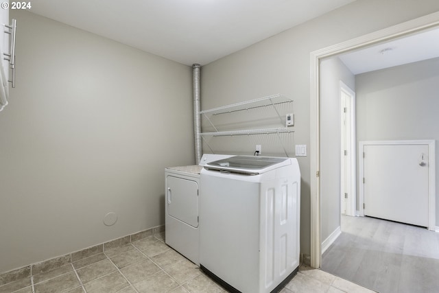 laundry area with laundry area, washer and clothes dryer, and baseboards