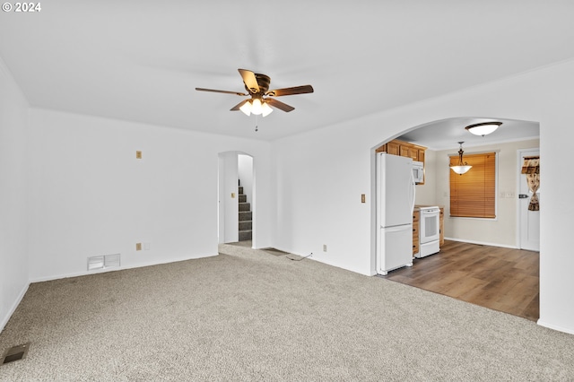 1655 NE 2nd St, Hermiston, OR 97838 - unfurnished living room with arched walkways, carpet floors, ceiling fan, stairs, and baseboards