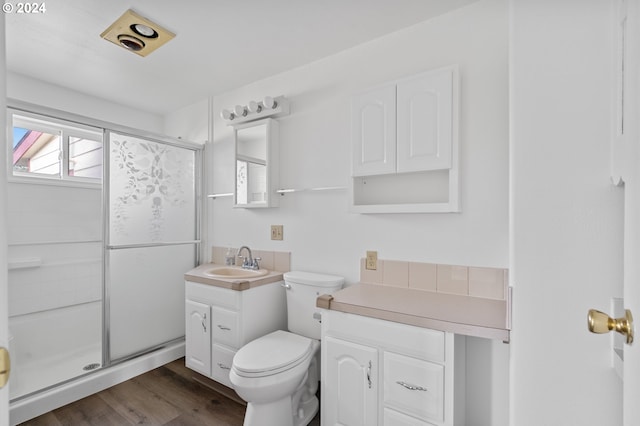 bathroom with an enclosed shower, wood-type flooring, toilet, and vanity