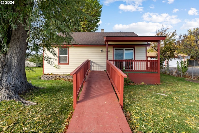 bungalow-style home featuring a front lawn and a deck