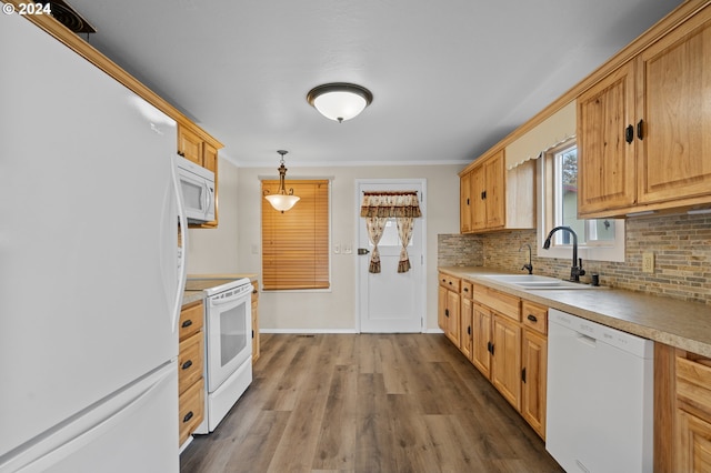 kitchen featuring hardwood / wood-style floors, sink, tasteful backsplash, white appliances, and decorative light fixtures