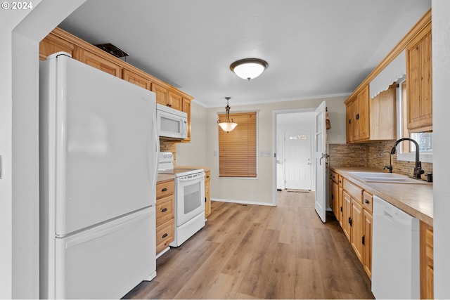 kitchen with hanging light fixtures, sink, tasteful backsplash, light hardwood / wood-style flooring, and white appliances