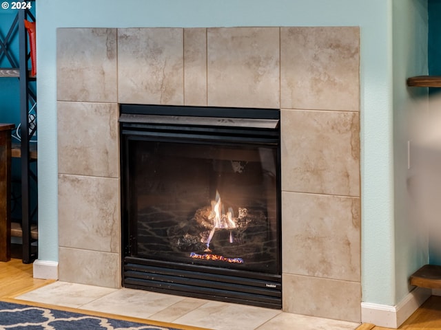 room details featuring a tiled fireplace and wood-type flooring