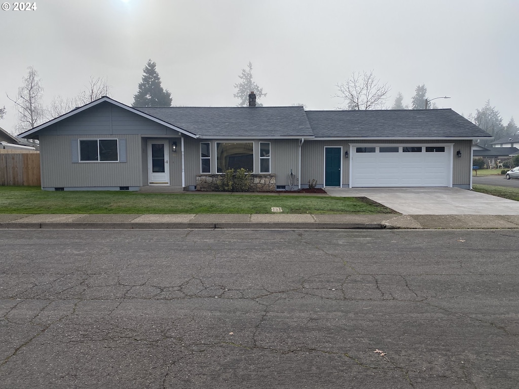 ranch-style house with a garage and a front yard