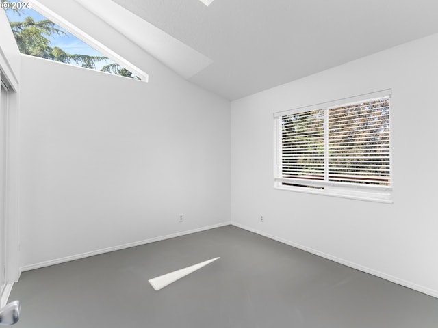 unfurnished room with vaulted ceiling