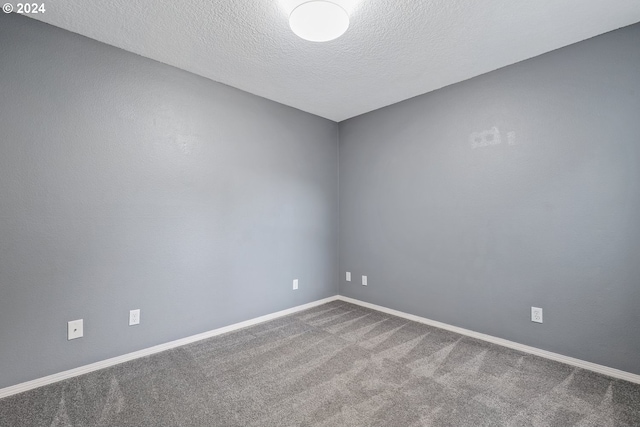 spare room with a textured ceiling and carpet floors