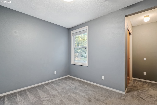 carpeted empty room with a textured ceiling