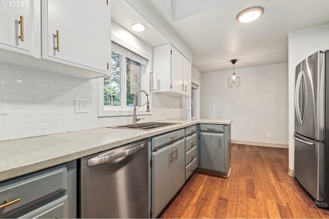 kitchen featuring light wood-type flooring, stainless steel appliances, tasteful backsplash, and sink