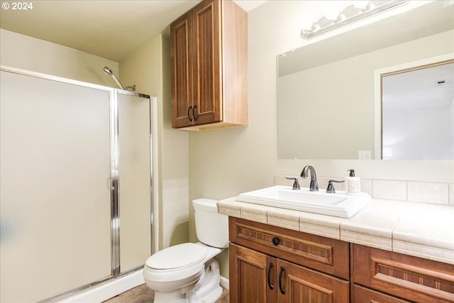 bathroom with vanity, toilet, and an enclosed shower