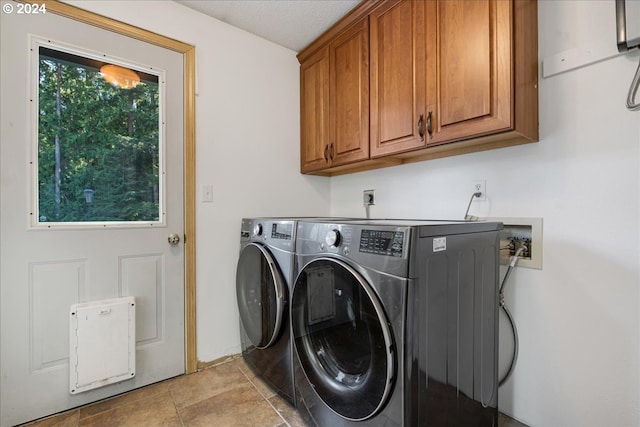 laundry area with separate washer and dryer, cabinets, a textured ceiling, and light tile patterned flooring