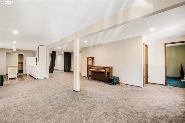 basement featuring light colored carpet and white refrigerator